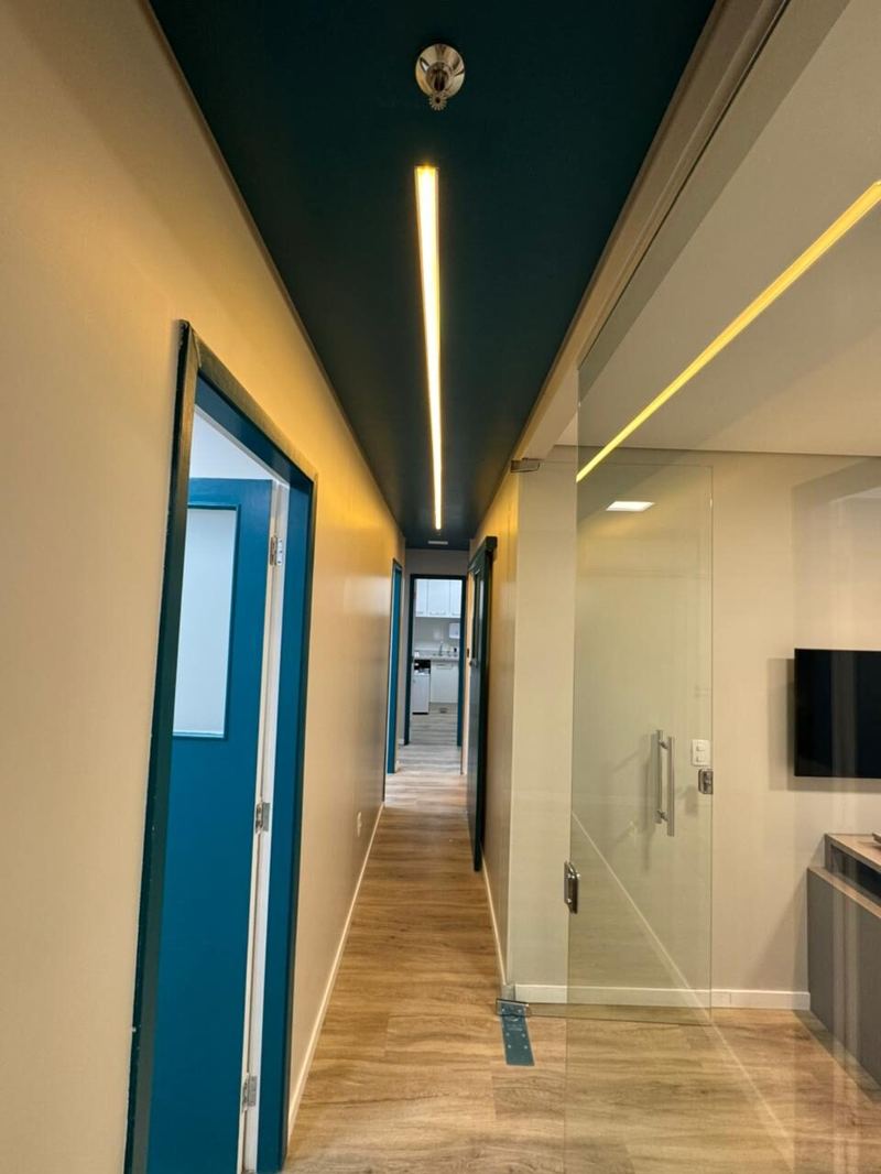 Triuno: corredor com teto azul e iluminação linear